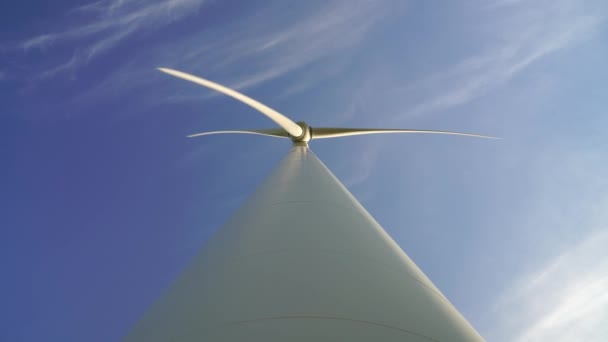 Blades of a large wind turbine in a field against a background of cloudy blue sky on the horizon with a beautiful hills. Alternative energy sources. Windy park. Ecological energy.Industrial — Stock Video