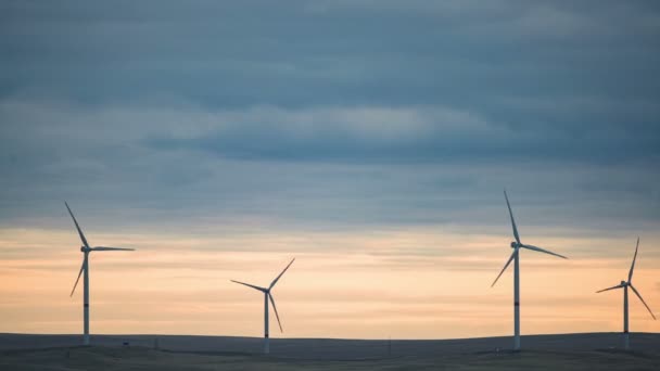 Schaufeln einer großen Windkraftanlage auf einem Feld vor einem wolkenverhangenen blauen Himmel am Horizont mit schönen Hügeln. Alternative Energiequellen. Windiger Park. Ökologische Energie.Industrie — Stockvideo