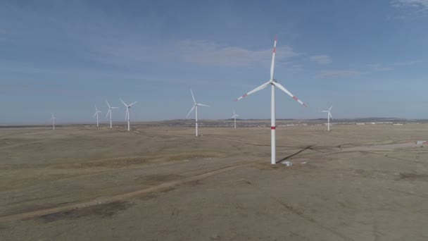 Bladen van een grote windturbine in een veld tegen een achtergrond van troebele blauwe lucht aan de horizon met een prachtige heuvels. Alternatieve energiebronnen. Winderig park. Ecologische energie.Industrieel — Stockvideo