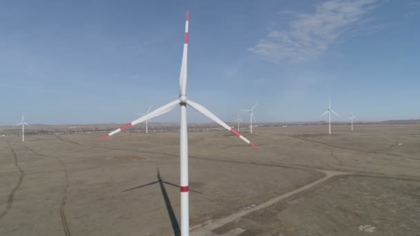 Blades of a large wind turbine in a field against a background of cloudy blue sky on the horizon with a beautiful hills. Alternative energy sources. Windy park. Ecological energy.Industrial — Stock Video