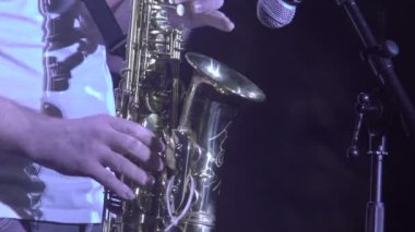 Konserde bandosu olan saksafoncu müzisyen. Müzik grubu şarkı söylüyor, sahne performansları sergiliyor. Caz grubunda solo çalan saksafoncu, hafif sahnede şarkı söylüyor.