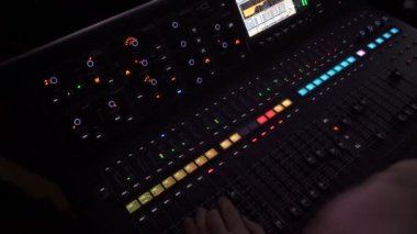 Ses yapımcısı eli, profesyonel bir kayıt stüdyosunda düzenleme araçlarıyla bir müzik mikseri kullanıyor..