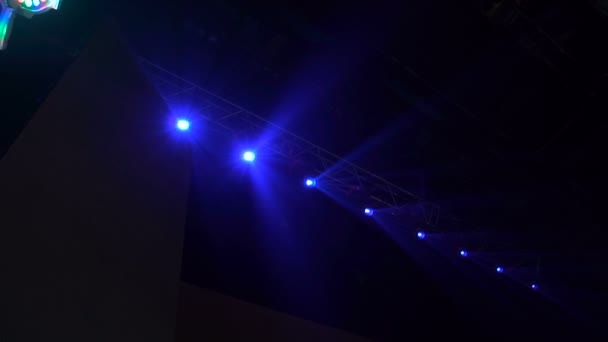 Pódium s barevnými reflektory. Světla se rozsvěcují ze tmy. — Stock video
