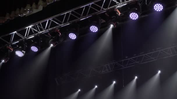 Proyectores de colores cuelgan en una granja musical. Proyectores girando y brillando en la sala de conciertos. Tecnología de escenario de iluminación automatizada. — Vídeos de Stock