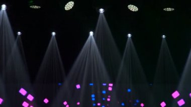 Sahne ışıkları çerçevesinin animasyonu. Parlak sahne ışıkları yanıp sönüyor. Spot ışıkları, koyu mavi spot ışıkları, siyah arka plana vuruyor..