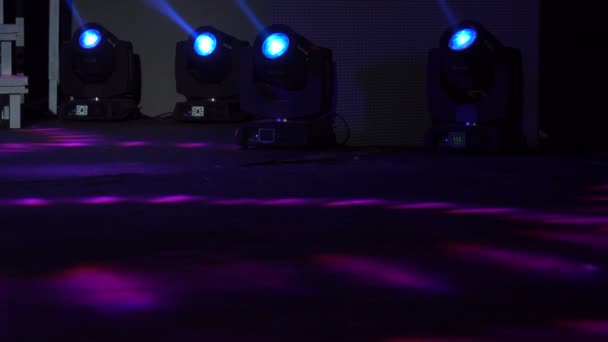 Cuatro proyectores de colores en la granja de luces de escenario. Luces de escenario brillantes y brillantes proyectores de proyectores de entretenimiento de movimiento intermitente en el foco de luz suave azul oscuro golpean sobre el fondo negro. — Vídeo de stock