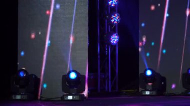Sahne ışıkları çiftliğinde dört renkli projektör. Parlak sahne ışıkları yanıp sönüyor. Spot ışıkları, koyu mavi spot ışıkları, siyah arka plana vuruyor..