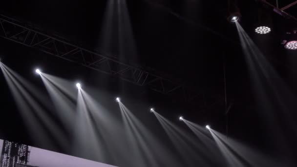Animatie van het frame van het podium. Heldere glanzende schijnwerpers knipperende beweging entertainment spotlight projectoren in het donker, veelkleurige zachte licht spotlight staking op zwarte achtergrond. — Stockvideo