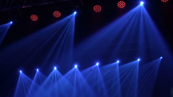 Animation der Bühnenbeleuchtung. Hell glänzende Bühnenlichter blinkende Bewegungs-Entertainment-Scheinwerfer im dunklen, blauen Softlight-Scheinwerfer auf schwarzem Hintergrund. — Stockvideo