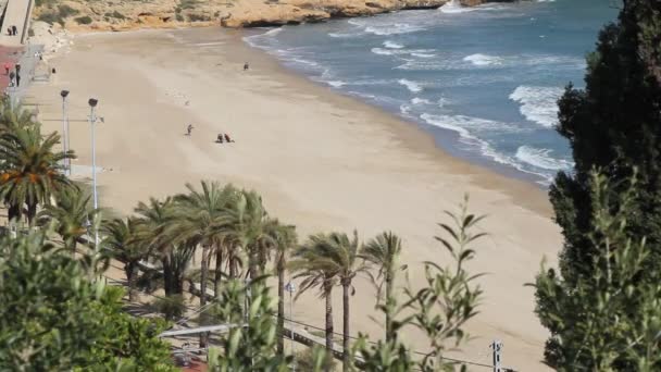 Beach, Tarragona tartományban, Katalóniában. Homok, víz, hullámok, fák és néhány ember. — Stock videók