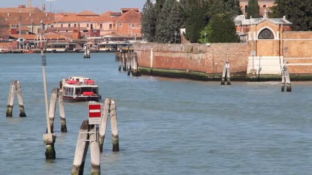Vattenbussen korsa lagunen i Venedig. Delar av tegelvägg och trästolpar i vattnet synligt. — Stockvideo