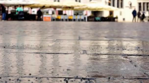 Panorera skott: Regnet smattrande på torget — Stockvideo