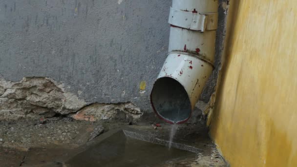 Agua de lluvia saliendo de una tubería de salida de agua — Vídeo de stock