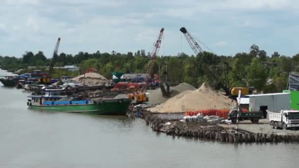 Mekong Nehri küçük limanda. Vinçler yükleme ve boşaltma gemi ve kamyon. — Stok video