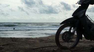 Deniz kıyısı ve kumsalda Park motosiklet kadın silüeti