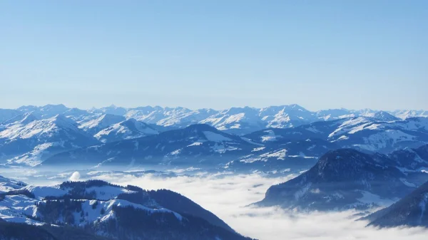Mountains with snow above clouds — Stock Photo, Image