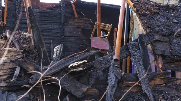 Yanık aşağı bir ev kalıntıları. Eski sandalye asılı yukarıdaki panoları, plakalar ve diğer ahşap malzeme bir ev yandı.
