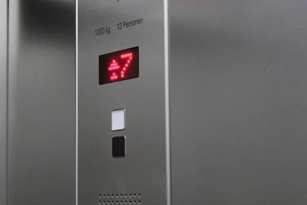 Affichage d'un ascenseur indiquant que le septième étage est atteint. Feux rouges indiquant le numéro sept et flèches vers le haut . Photos De Stock Libres De Droits