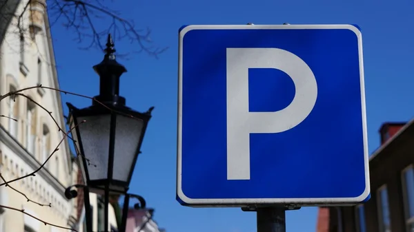 Straat teken parkeerzone voor oude historische gebouwen en de blauwe hemel. Naast een oude straat lamp. Stockafbeelding