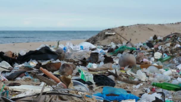 Poubelles comme les bouteilles et sacs en plastique ou autres déchets sur la plage polluée — Video