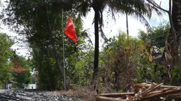Drapeau du Vietnam agitant sur le mât de drapeau tandis que la moto courir le long de la route à côté — Video
