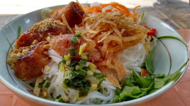 Beyaz bir kase erişte ve et ve sebze