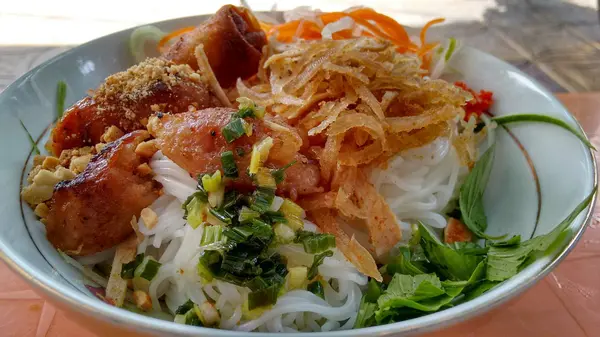 Beyaz bir kase erişte ve et ve sebze