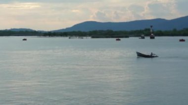 Arka planda dağlar önünde mavi okyanus crossing onun balıkçı teknesi ile bulanık tanımlanamayan balıkçı. Odaklanmamış soyut vurdu.
