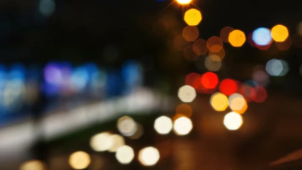 Blurry unfocused lights of cars and motorcycles on road at night