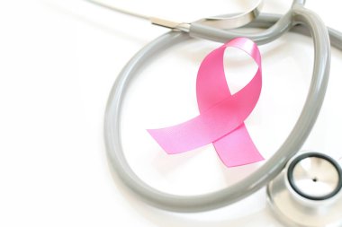 Beyaz arka planda pembe kurdele ve steteskop, yakın plan. Göğüs kanseri farkındalığı konsepti