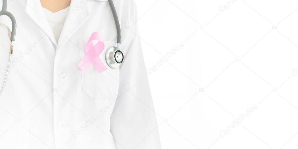 closeup of a young caucasian doctor woman with a pink ribbon for the breast cancer awareness pinned in the flap of his white coa