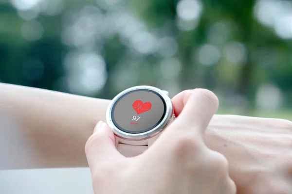 Close up smartwatch with app heart rate icon on the screen. Health care concept.