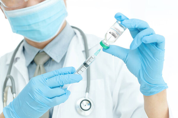 Coronavirus COVID-19 vaccine. Doctor holding Corona virus vaccine and syringe using for prevent COVID-19 infection. Medicine and Healthcare concept.