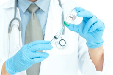 Coronavirus COVID-19 aşısı. Corona virüsü aşısını ve şırıngayı elinde tutan doktor COVID-19 enfeksiyonunu önlemek için kullanıyor. Tıp ve Sağlık Hizmetleri kavramı.