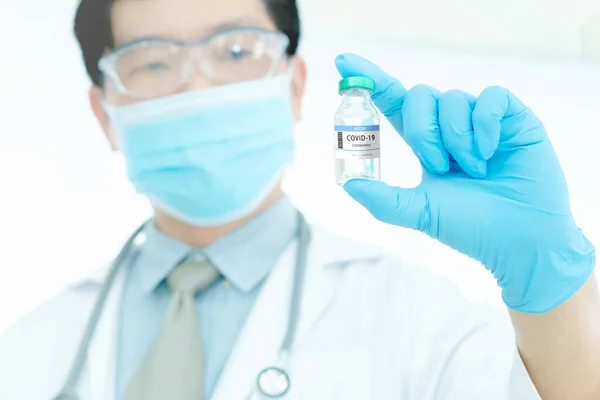 Development and creation of a coronavirus vaccine COVID-19 .Coronavirus Vaccine concept in hand of doctor blue vaccine jar. Vaccine Concept of fight against coronavirus.