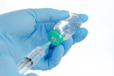 Aşılar virüse karşı savaşıyor, doktor ya da bilim adamı laboratuarda elinde sıvı aşılarla bir şırınga tutuyor. Kavram: hastalıklar, tıbbi bakım. 