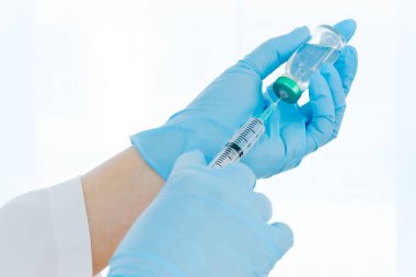 Aşılar virüse karşı savaşıyor, doktor ya da bilim adamı laboratuarda elinde sıvı aşılarla bir şırınga tutuyor. Kavram: hastalıklar, tıbbi bakım. 