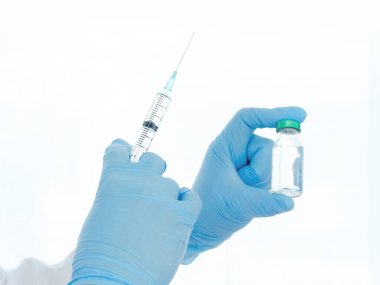 Aşılar virüse karşı savaşıyor, doktor ya da bilim adamı laboratuarda elinde sıvı aşılarla bir şırınga tutuyor. Kavram: hastalıklar, tıbbi bakım