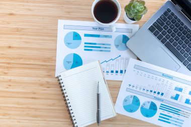 Evden çalışıyorum. Masasında dizüstü bilgisayarı, boş not defteri, sehpanın üzerinde kahve fincanı ve kalem vardı. Düz görünüm kopyalama aralığı.