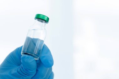 Aşılar virüse karşı savaşıyor, doktor ya da bilim adamı laboratuarda elinde sıvı aşılarla bir şırınga tutuyor. Kavram: hastalıklar, tıbbi bakım. 