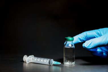 Siyah arka planda potansiyel deneme aşaması konsepti. Şişeleri steril şırıngayla kapatın. Araştırma ve Geliştirme, Aşılama Konsepti.