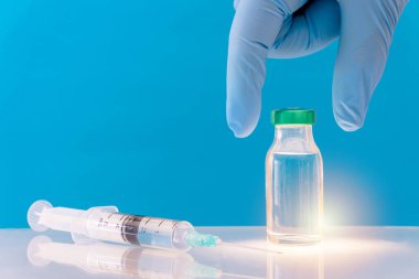 Mavi arka planda potansiyel deneme aşaması konsepti. Şişeleri steril şırıngayla kapatın. Araştırma ve Geliştirme, Aşılama Konsepti.