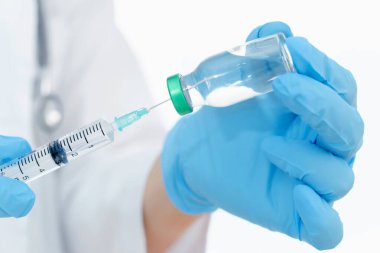 Aşılar virüse karşı savaşıyor, doktor ya da bilim adamı laboratuarda elinde sıvı aşılarla bir şırınga tutuyor. Kavram: hastalıklar, tıbbi bakım. 