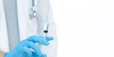 Aşılar virüse karşı savaşıyor, doktor ya da bilim adamı laboratuarda elinde sıvı aşılarla bir şırınga tutuyor. Kavram: hastalıklar, tıbbi bakım.