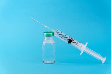 Mavi arka planda potansiyel deneme aşaması konsepti. Şişeleri steril şırıngayla kapatın. Araştırma ve Geliştirme, Aşılama Konsepti.