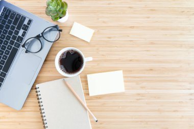 Düz kompozisyon, defter, kalem, kahve, bitki, dizüstü bilgisayar ahşap arka planda. Üst görünümü kavra