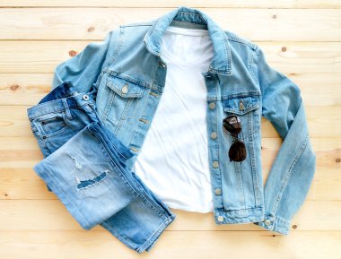 Beyaz tişört modeli ve kahverengi ahşap arka planda kot pantolon. Şablon, düz yat