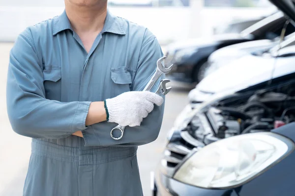 Motor mechanic.  Hand of car mechanic with wrench. Auto repair garage.