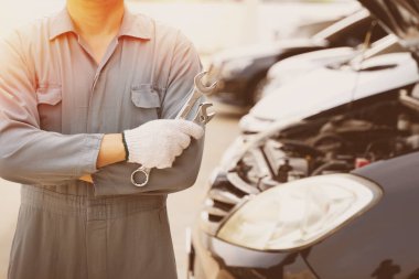 Motor tamircisi. İngiliz anahtarı olan bir araba tamircisi. Otomatik tamir garajı.