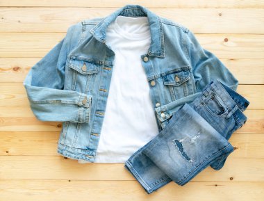 Beyaz tişört modeli ve kahverengi ahşap arka planda kot pantolon. Şablon, düz yat